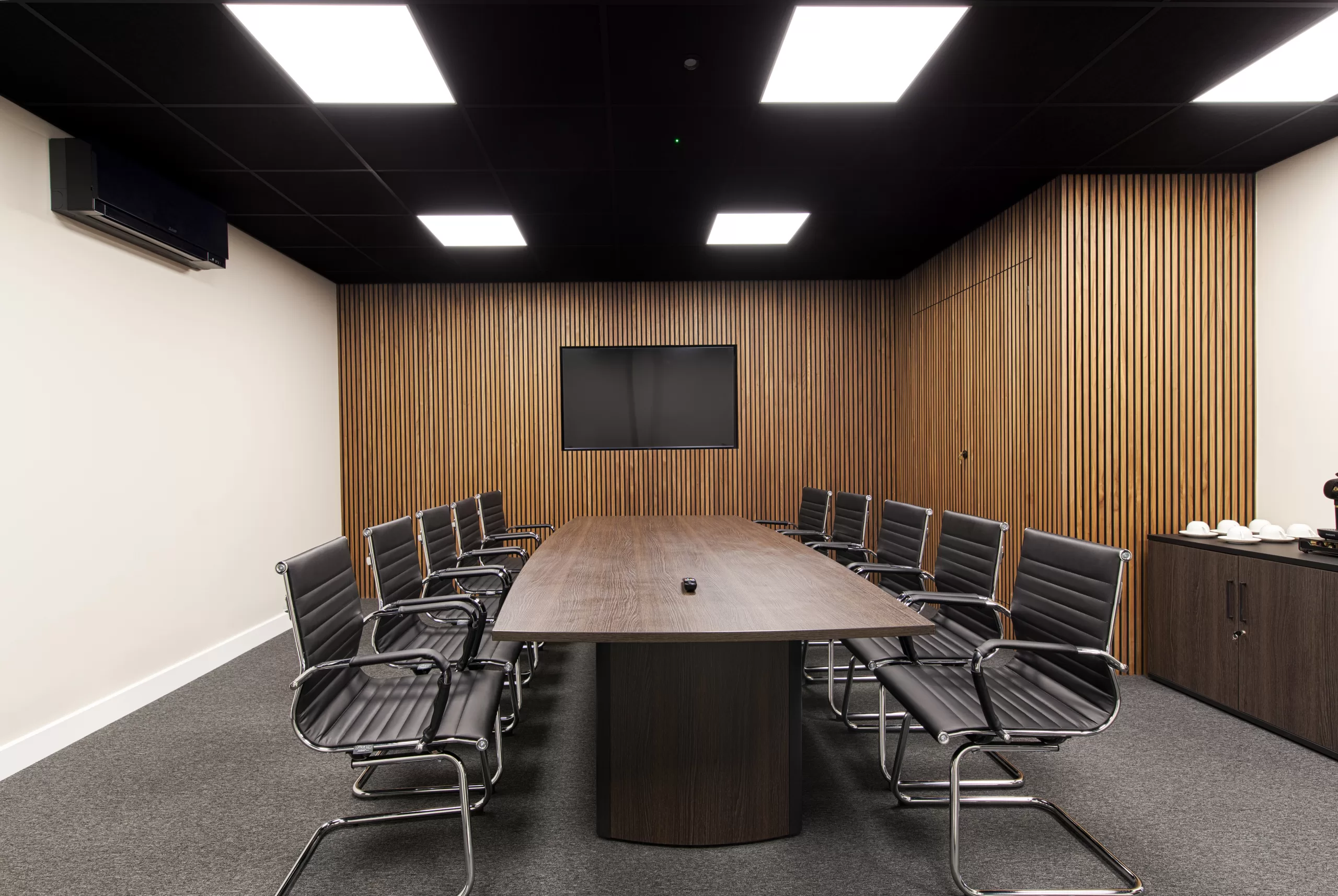 boardroom with wood cladding and rectangle led ceiling lights