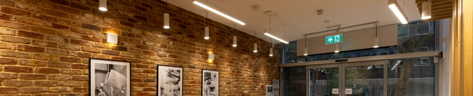 LED Suspended downlights against a brick wall